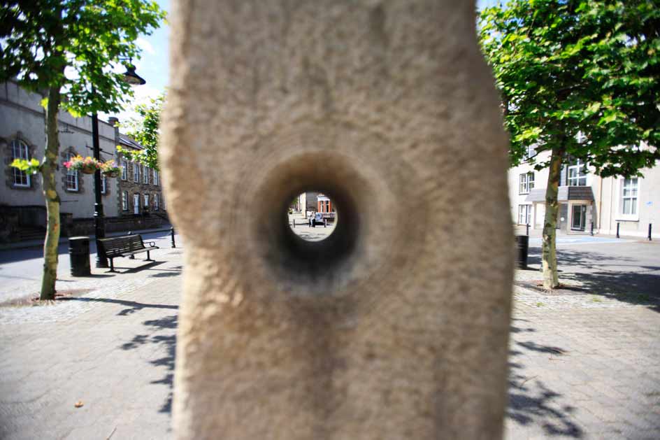 close up photo of the stone moon sculpure with square in the background